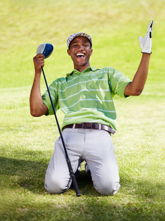 What a shot. an african american on his knees celebrating a great shot.の写真素材