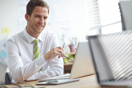 Planning ahead for a bright future in business management. A handsome young businessman sitting at...