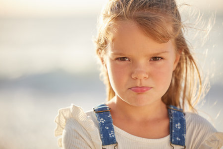 Blonde caucasian little girl with pouted lips looking angry, annoyed and stubborn while spending a...