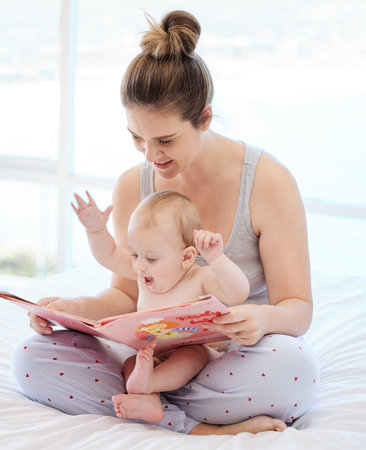 A youthful song of laughter. a young mother bonding with her baby boy while reading a book at home.
