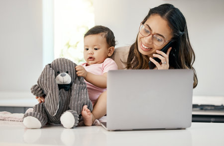How do I manage work from home with my baby. a woman working on her laptop and talking on her cellphone while sitting with her baby on her lap.の写真素材
