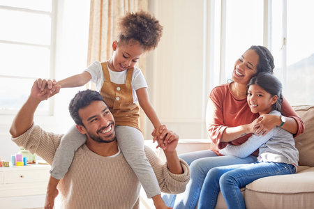 Happy mixed race family smiling while playing in the lounge together. Young hispanic couple spending...