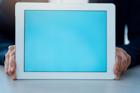 Presenting the latest and greatest. Closeup shot of an unrecognisable businesswoman holding a digital tablet with a blank screen in an office.の写真素材