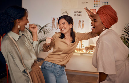 Fashion designer, high five or success in teamwork collaboration, partnership store deal or sales growth in manufacturing workshop. Smile, happy or excited creative women in night clothing boutiqueの写真素材