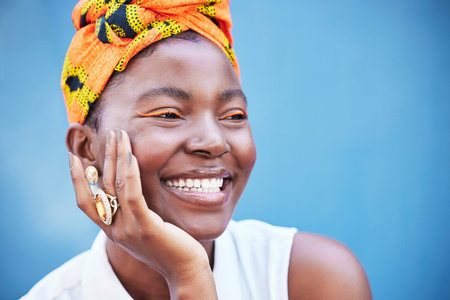 Makeup, black woman and smile with head wrap, eye lash color or confident on blue studio background....