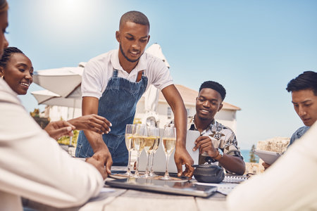 Beach restaurant, waiter and champagne celebration with friends. Hospitality, fine dining and a...
