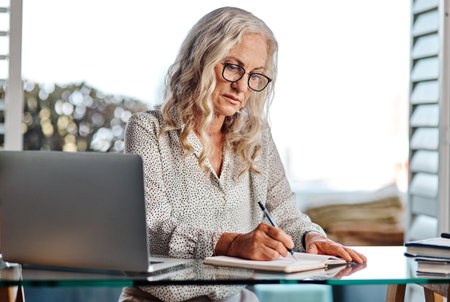 Shes quite good at handling her business from home. an attractive senior businesswoman working from home.の写真素材