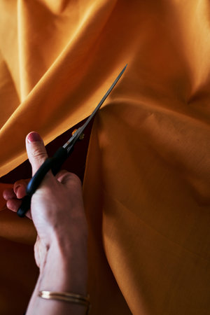 My designs are cut out for my clients. an unrecognizable fashion designer cutting fabric.