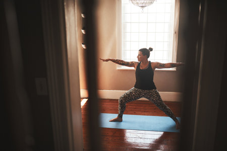 Lifes about finding balance. a young woman practising yoga at home.の写真素材
