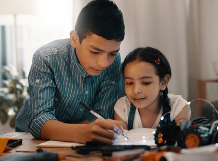Well be building robots on our own in no time. two adorable young siblings doing robotics homework...
