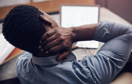 My neck cant do it anymore. a handsome young male architect suffering with neck pain while working in a modern office.の写真素材