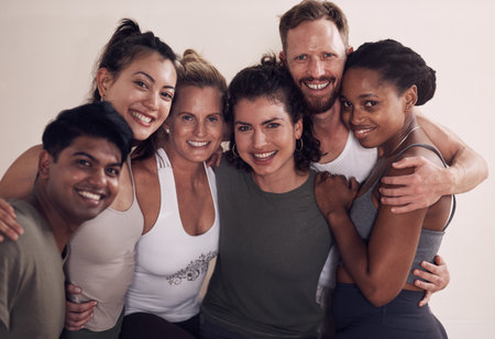 Its yoga time. Portrait of a group of active young people posing together against a wall in yoga class.の写真素材