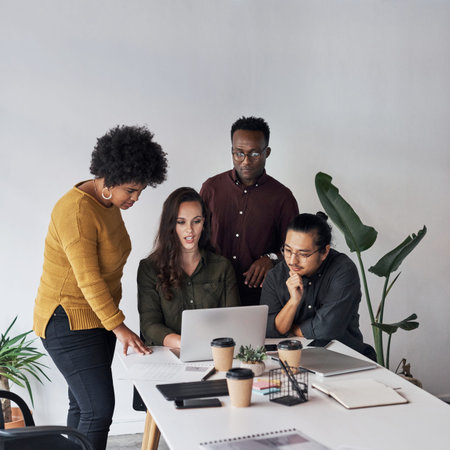 Teamwork divides tasks and multiplies success. a diverse group of businesspeople working on a laptop...