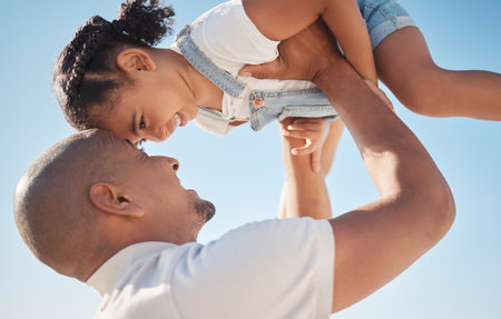 Father with girl in air, support and happy for quality time, playful and bonding together outdoor. Man, daughter and holding to sky, love and happiness for break, lifting female child and family gameの写真素材