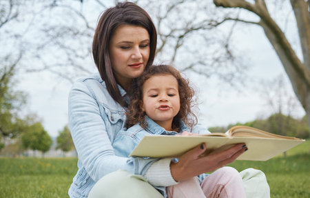 Nature, mother and child reading book in park, story time in park or garden on summer weekend....