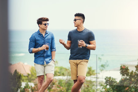 Theres always a lot to discuss when we get together. two handsome young men having drinks and...