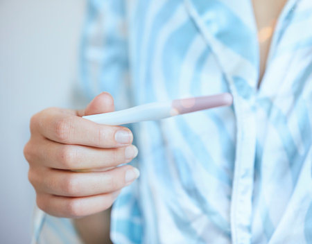 Pregnancy test, woman and hands check results of medical information at home. Closeup, fertility stick or family planning for maternity wellness, pregnant hormone or ivf healthcare treatment for babyの写真素材