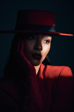 Beauty, art and fashion of aesthetic woman in studio with dark shadow, makeup and cosmetics for retro or vintage show girl background. Face of 90s female model with hat and classic style on blackの写真素材