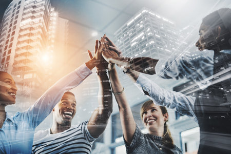 Were going to make success ours. Closeup shot of a group of businesspeople high fiving each other in...
