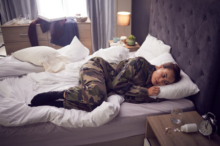 Thinking, pills or woman with insomnia, depression or drugs overdose or mental disorder struggle in bedroom. Stressed, dangerous or sad girl on house pillow with bad mental health anxiety problemsの写真素材