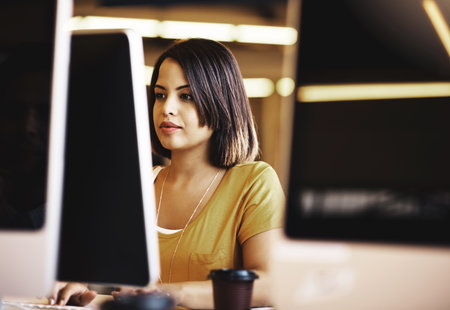 Her focus is on her work. a businesswoman working on a computer in an modern office.の写真素材