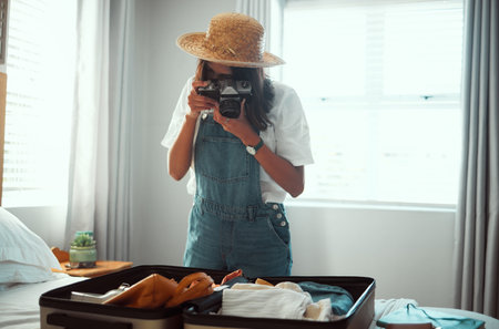 Photography, travel luggage and woman with camera shooting suitcase clothes for summer vacation. Home bedroom, memory picture and photographer girl going on global holiday, adventure journey or tripの写真素材