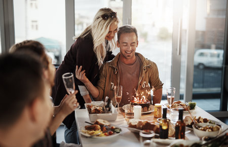She made sure that his birthday is extra special. a young man celebrating his birthday with his friends.の写真素材