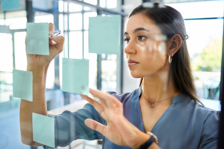Corporate woman, sticky notes and glass board for planning, brainstorming and strategy at modern...
