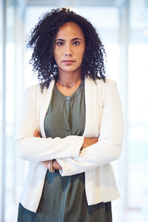 Feeling confident in her position. Portrait of an attractive young businesswoman standing in the office.の写真素材