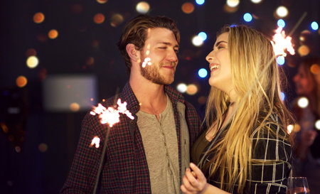 Shes the true sparkle of my life. an attractive young couple having fun with sparklers at a nightclub.の写真素材