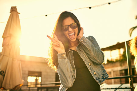 Feeling good, the beautiful day has lifted my mood. Portrait of an attractive young woman spending the day outside on a rooftop.の写真素材