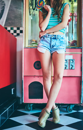 Lengthy legs. an unrecognizable young woman standing in a retro diner.の写真素材