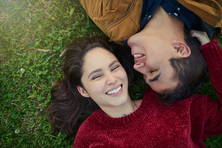 Everyone deserves someone who makes them smile. High angle shot of a happy young couple laying...