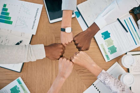 Diversity, fist hands and teamwork with documents on table for marketing business meeting, creative...