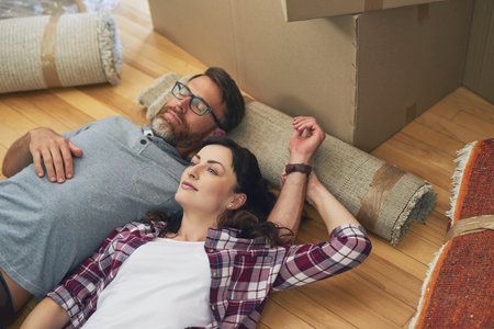 Saying goodbye is the hardest part. a couple relaxing together in their home on moving day.の写真素材