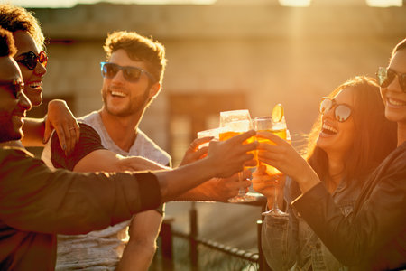 Together is our favorite place to be. a group of young diverse friends having a drink and spending the day outside on a rooftop.の写真素材
