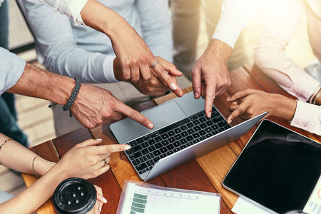 Technology brings it all together. a team of businesspeople pointing at a laptop during a meeting...