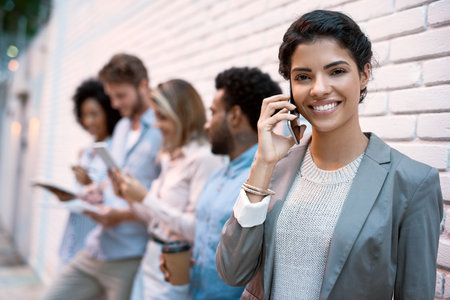 On the call helping clients with a design. young designers using different devices outside.の写真素材