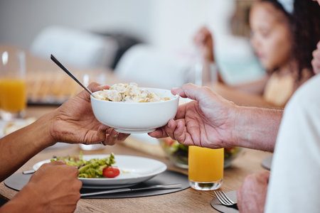 Food, lunch and hands pass bowl with delicious pasta at home. Brunch, fine dining and family or people eating and sharing a tasty, gourmet and healthy meal on table together in house dinning roomの写真素材