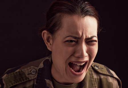 War, crying and military woman with ptsd, trauma and anxiety, screaming or shouting. Mental health, depression and face of female soldier from Ukraine with stress, pain and thinking of army memories.の写真素材