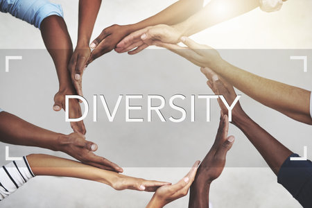Diversity makes the world go round. a group of businesspeople joining their hands in solidarity.の写真素材