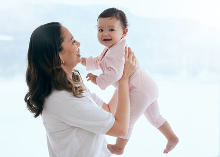 As long as shes happy. a mother holding her baby daughter at home.