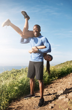 She makes me want to be stronger. a muscular man carrying his girlfriend over his shoulders.の写真素材