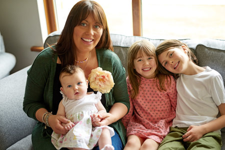 One big blessed family. Portrait of a mother bonding with her three little children at home.