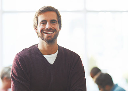 My mission is to bring success to my name. Portrait of a young businessman standing in an office.の写真素材