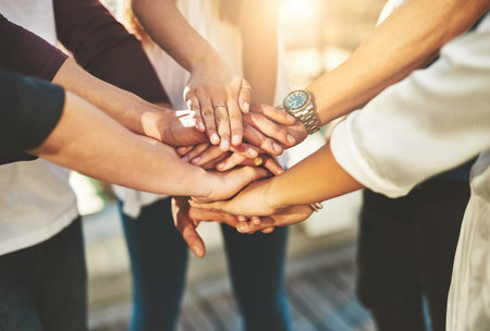 Together we can do more. an unrecognizable group of people putting their hands together in unity...
