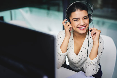 Im here to help. Cropped portrait of an attractive young businesswoman working late in a call...