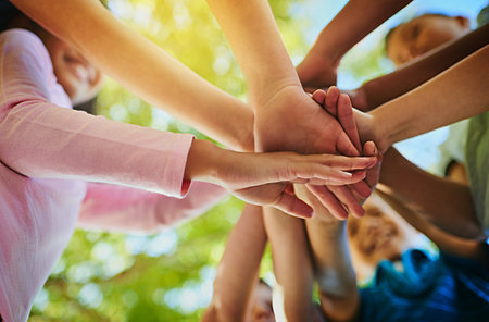 We all in this together. an unrecognizable group of young friends hands huddled together outside.