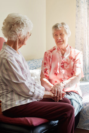 Those regular catch ups mean so much. two happy senior women chatting in a retirement home.