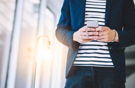 The business contact youll want to have in your phone. a businessman using a mobile phone in a modern office.の写真素材